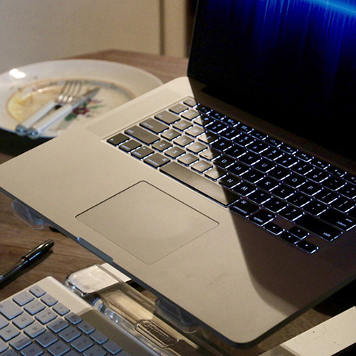 he Valley View 2018 image of a laptop keyboard, and next to it a saucer with a knife and fork, and leftover crumbs on it